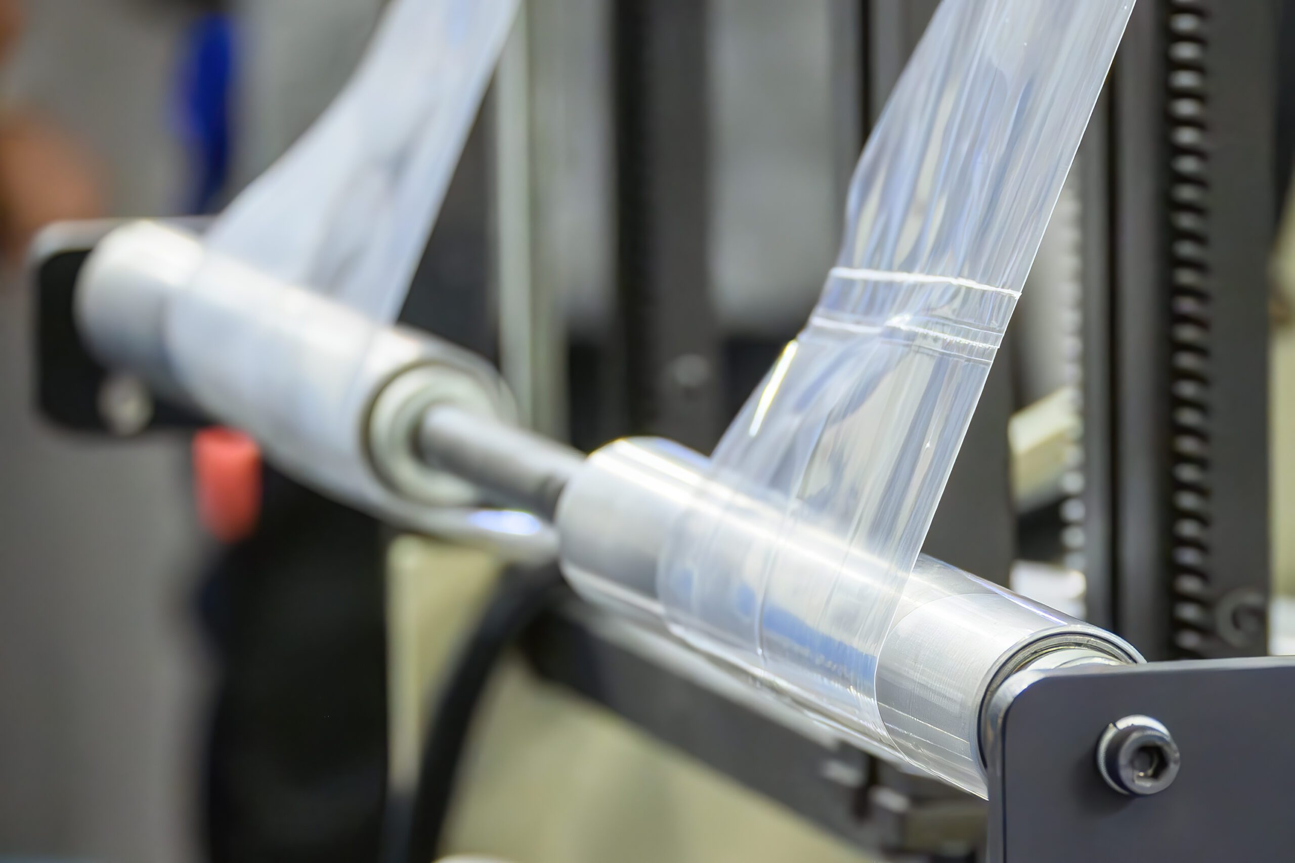 Close-up of a large plastic bag roll from a high-speed automated mass production process in a packaging factory.